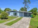 View of a single-story home with covered carport and driveway leading to a well-maintained lawn at 22219 Catherine Ave, Port Charlotte, FL 33952