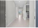 Bright and airy hallway featuring neutral walls and tile flooring, leading to other rooms at 2477 Gabel Oak Dr, North Port, FL 34289