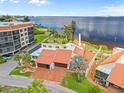 An aerial view showing the waterfront home, patio and surrounding lush landscaping, condo and water views at 25188 Marion Ave # 45, Punta Gorda, FL 33950
