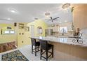 Bright kitchen with stainless steel appliances, an island with seating, and tiled backsplash with unique lighting at 25188 Marion Ave # 45, Punta Gorda, FL 33950