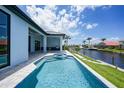 Backyard featuring a private pool, covered patio, and waterfront views on a sunny day at 2815 Coral Way, Punta Gorda, FL 33950