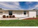 Home featuring a clean white exterior, concrete walkway, and tidy landscaping at 3497 Cohoes St, Port Charlotte, FL 33952