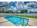 Inviting screened pool area with clear blue water, surrounded by a patio and lush greenery, perfect for relaxation at 4038 Corydon Ave, North Port, FL 34286