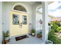 Charming entryway with decorative double doors, a transom window, and manicured landscaping at 976 Great Falls Nw Ter, Port Charlotte, FL 33948