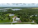Aerial view showcasing the property's boundaries, including a spacious home, metal building, and serene lake at 10810 Wheeler Pl, Punta Gorda, FL 33950