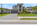 Stunning two-story home featuring a well-manicured lawn and gray brick driveway leading to a spacious two-car garage at 11105 Balfour E St, Venice, FL 34293