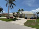 Attractive single-story home with well-maintained landscaping, mature palms and a circular driveway at 1128 Rum Cay Ct, Punta Gorda, FL 33950