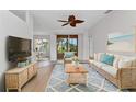 Comfortable living room features a cozy sofa, stylish rug, ceiling fan, and sliding glass doors to the backyard at 1605 Palace Ct, Punta Gorda, FL 33980
