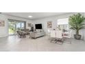 Large living room featuring neutral walls, tile floors, modern furniture, and views of the outdoor space at 24348 Nicobar Ln, Punta Gorda, FL 33955