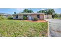This single-story home features a lush green lawn, small garden, and charming curb appeal at 25082 Harborview Rd, Punta Gorda, FL 33980