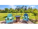 Relaxing backyard seating area, featuring mature landscaping and peaceful green space at 25272 E Lenox Cir, Punta Gorda, FL 33950