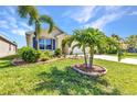Landscaped front yard featuring beautiful green grass and mature landscaping, enhancing curb appeal at 25272 E Lenox Cir, Punta Gorda, FL 33950
