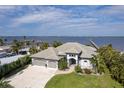 Waterfront home with lush landscaping, an ample driveway and private dock beyond at 25462 Shore Dr, Punta Gorda, FL 33950