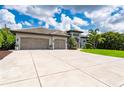 Beautifully landscaped home with concrete driveway and a large three car garage at 25462 Shore Dr, Punta Gorda, FL 33950