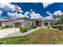 Beautiful single-story home with a gray driveway, tropical foliage, and a charming entryway at 26254 Stillwater Cir, Punta Gorda, FL 33955