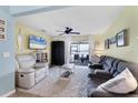 Bright living room with plush seating, a ceiling fan, and sliding glass doors to the outdoors at 26310 Rampart Blvd # 504, Punta Gorda, FL 33983