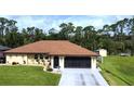 Charming home featuring a well-maintained lawn, a neutral color scheme, and a spacious screened garage at 319 Kindred Blvd, Port Charlotte, FL 33954
