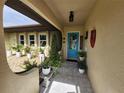 Inviting front entrance with a beautifully decorated blue door and lovely decorative plants at 319 Kindred Blvd, Port Charlotte, FL 33954