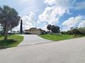 Home exterior with a long driveway, three car garage, and ample green space in a serene setting at 3456 Highlands Rd, Punta Gorda, FL 33983