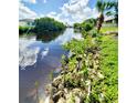 Scenic canal view with lush vegetation and reflections of the cloudy sky at 3456 Highlands Rd, Punta Gorda, FL 33983