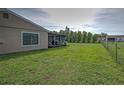 View of a large backyard featuring a screened-in porch and chain-link fence at 3512 Nekoosa St, North Port, FL 34287