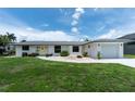 Charming one-story home with a well-manicured lawn and a welcoming entrance with a bright yellow front door at 4051 Rock Creek Dr, Port Charlotte, FL 33948