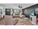 Comfortable living room featuring stylish furniture, a ceiling fan, and natural light from the windows at 457 Glenridge Nw Ave, Port Charlotte, FL 33952