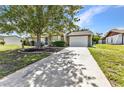 Charming single-story home featuring well-kept landscaping, a cozy facade, and a driveway leading to a garage at 496 Fletcher St, Port Charlotte, FL 33954
