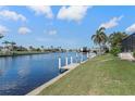 Beautiful water view with dock extending from the lawn and palm trees lining the canal at 531 Madrid Blvd, Punta Gorda, FL 33950