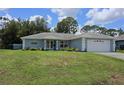 Well-maintained single-story home with a green lawn and an attached two-car garage at 6341 Opa Locka Ln, North Port, FL 34291