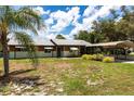 View of a charming single-story home with a metal roof, carport, and a well-maintained front yard at 8513 Heister St, Punta Gorda, FL 33982