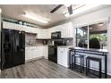 Bright kitchen with white cabinetry, black appliances, and a convenient breakfast bar seating area at 8513 Heister St, Punta Gorda, FL 33982