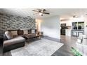 Modern living room featuring a stylish brick wall, cozy brown sectional sofa and contemporary decor at 8513 Heister St, Punta Gorda, FL 33982