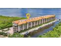 Aerial view of a waterfront condo building with boat docks and lush landscaping at 900 E Marion Ave # 1203, Punta Gorda, FL 33950