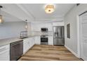 A modern kitchen with stainless steel appliances, white cabinets and wood floors at 900 E Marion Ave # 1203, Punta Gorda, FL 33950
