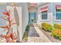 Close-up of the home's inviting entrance with well-maintained landscaping and a charming turquoise door at 10478 Coquina Ct, Placida, FL 33946