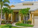 Inviting front entrance with lush landscaping, elegant columns, and a white-tiled roof at 1323 Mineo Dr, Punta Gorda, FL 33950