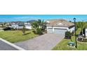 Stunning curb appeal, featuring tropical landscaping, a two-car garage and a brick paver driveway at 14436 Ponce De Leon Trl, Port Charlotte, FL 33981