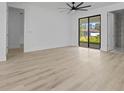 Primary bedroom suite with wood-look flooring, sliding glass doors, and a ceiling fan at 17156 Eugene Ave, Port Charlotte, FL 33954