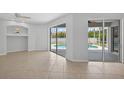 Spacious living area featuring tile flooring and sliding glass doors to the pool area at 1762 Mincey Ter, North Port, FL 34286