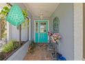 Charming front entryway with teal door, decorative plants, and a brick floor at 2141 Rio De Janeiro Ave, Punta Gorda, FL 33983