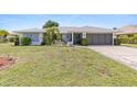 Charming single-story home featuring a well-manicured lawn, inviting entrance, and an attached two-car garage at 2141 Rio De Janeiro Ave, Punta Gorda, FL 33983