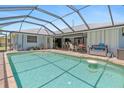 A large screened-in pool with patio furniture, perfect for outdoor relaxation and entertaining guests at 2141 Rio De Janeiro Ave, Punta Gorda, FL 33983