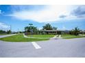 Welcoming single-story home with a lush green lawn, fenced yard, and convenient two-car garage on a sunny corner lot at 21539 Gladis Ave, Port Charlotte, FL 33952
