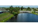 Scenic view of a serene waterfront property featuring lush greenery, a calming water feature, and quaint neighborhood setting at 21539 Gladis Ave, Port Charlotte, FL 33952
