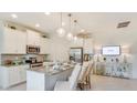 Modern kitchen with white cabinets, granite countertops, stainless appliances and bar seating at 2308 Oberon Ln, Punta Gorda, FL 33983