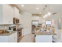 Bright kitchen with white cabinets, granite countertops, stainless appliances and bar seating at 2308 Oberon Ln, Punta Gorda, FL 33983