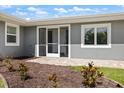 Charming exterior showcasing a gray facade, an inviting front entry, and well-maintained landscaping at 2309 Conway Blvd, Port Charlotte, FL 33952