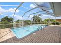 Inviting screened-in pool area with brick-paved deck and views of the canal at 2309 Conway Blvd, Port Charlotte, FL 33952