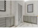 Modern bathroom featuring double vanity, gray cabinets, textured white tile and a marble floor at 24317 Treasure Island Blvd, Punta Gorda, FL 33955